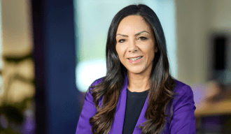 Woman with dark brunette hair wearing a purple blazer